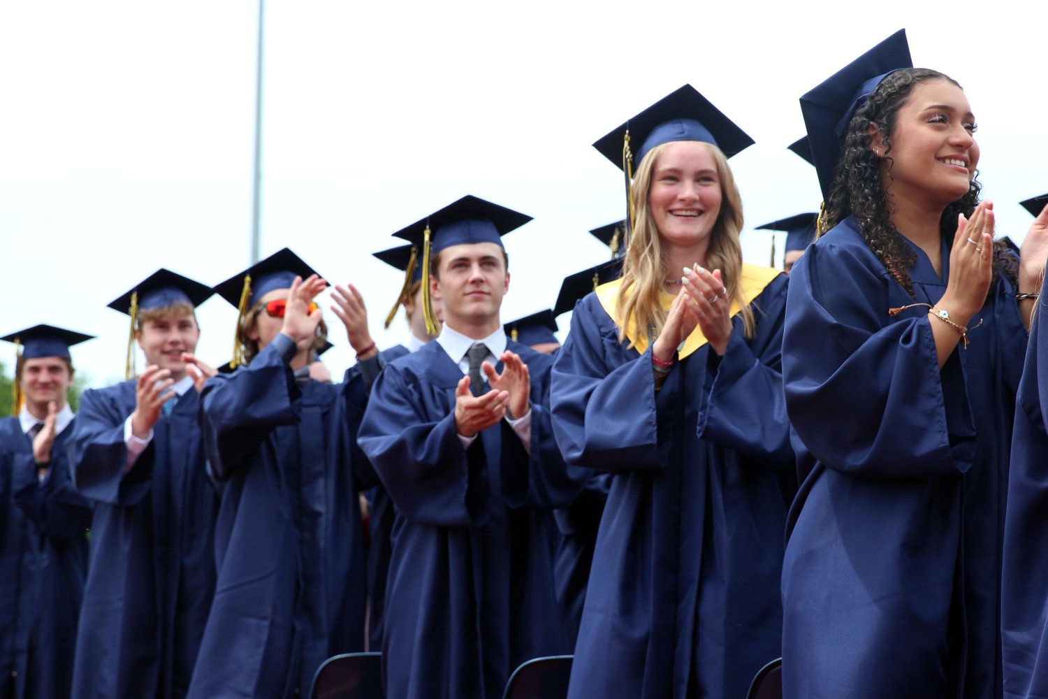 Members of Helias Catholic High School’s graduating Class of 2022 stand up and applaud their family, friends and teachers during English instructor Patricia Seifert’s address at the Commencement Exercises on May 22.